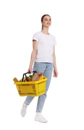 Photo of Woman with shopping basket full of products on white background