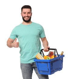 Photo of Man with shopping basket full of products showing thumbs up on white background