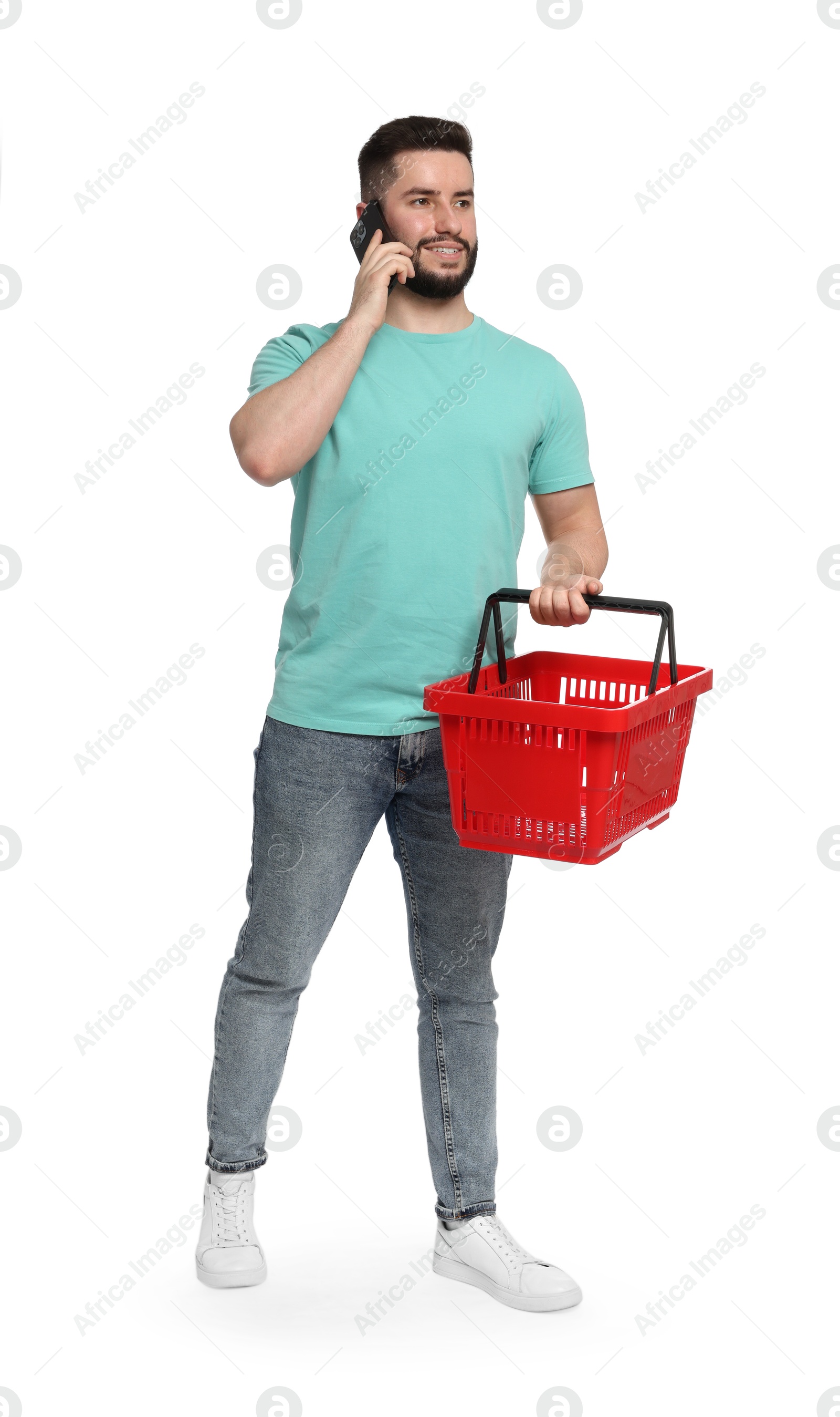 Man with empty shopping basket talking on smartphone against white background Photo of Man with empty shopping basket talking on smartphone against white background
