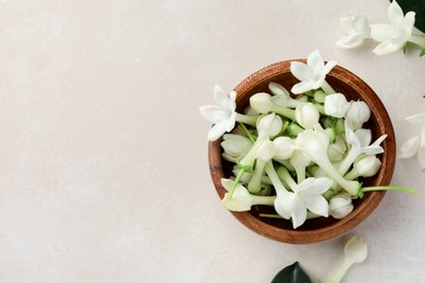 Photo of Bowl with jasmine flowers on beige table, flat lay. Space for text