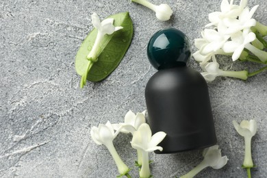 Photo of Perfume and jasmine flowers on grey table, flat lay. Space for text