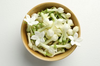 Photo of Beautiful jasmine flowers in bowl on white table, top view