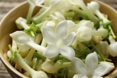 Photo of Beautiful jasmine flowers in bowl, closeup view