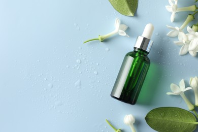 Photo of Bottle of essential oil, jasmine flowers and leaves on light blue background, flat lay. Space for text