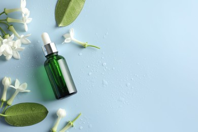 Photo of Bottle of essential oil, jasmine flowers and leaves on light blue background, flat lay. Space for text