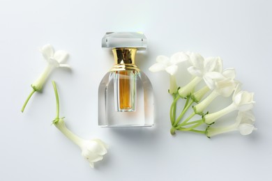Photo of Perfume and jasmine flowers on white background, flat lay