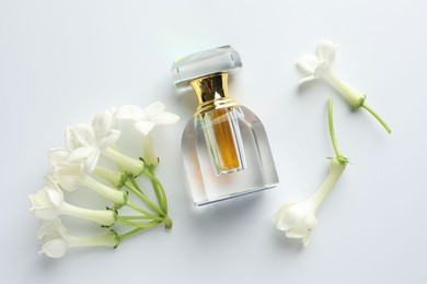 Photo of Perfume and jasmine flowers on white background, flat lay