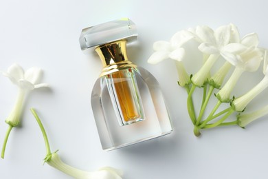 Photo of Perfume and jasmine flowers on white background, flat lay