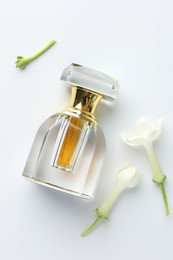 Photo of Perfume and jasmine flowers on white background, flat lay