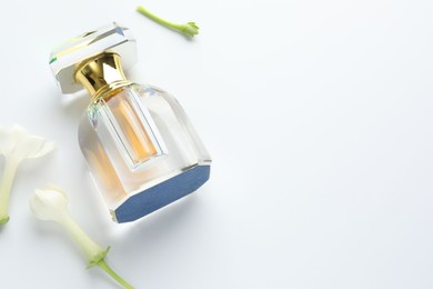Photo of Perfume and jasmine flowers on white background, above view. Space for text