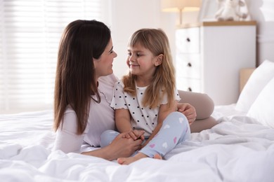 Photo of Mother and daughter on bed at home