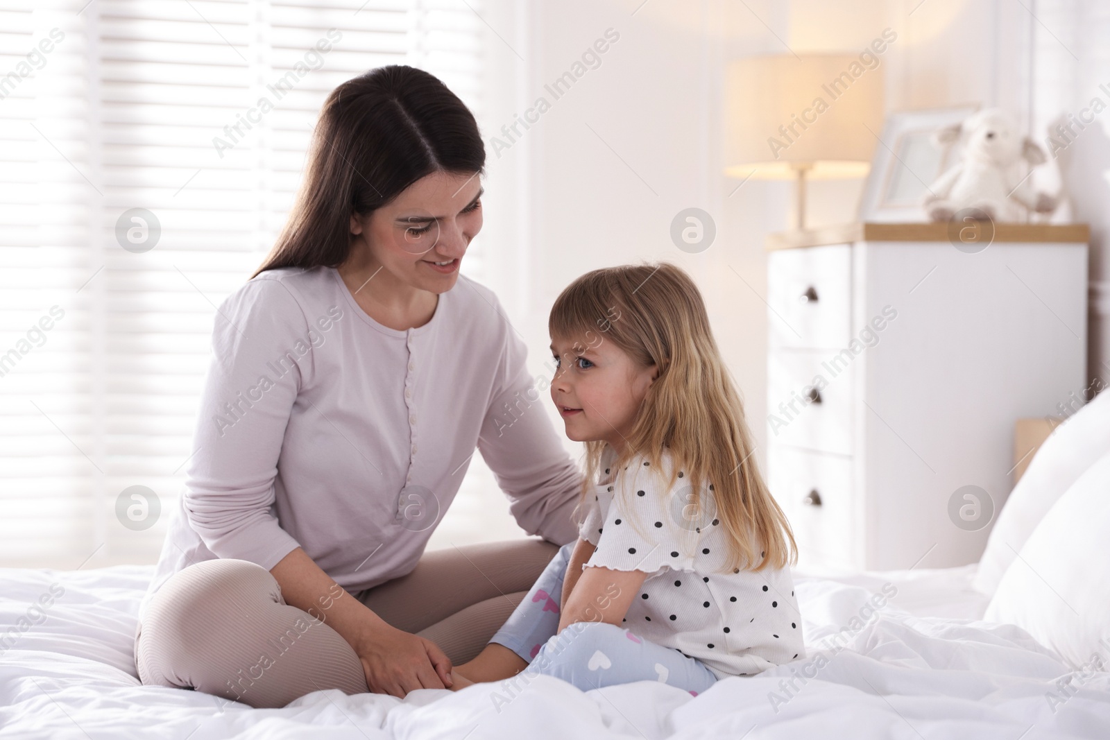 Mother and daughter on bed at home Photo of Mother and daughter on bed at home