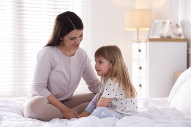 Photo of Mother and daughter on bed at home