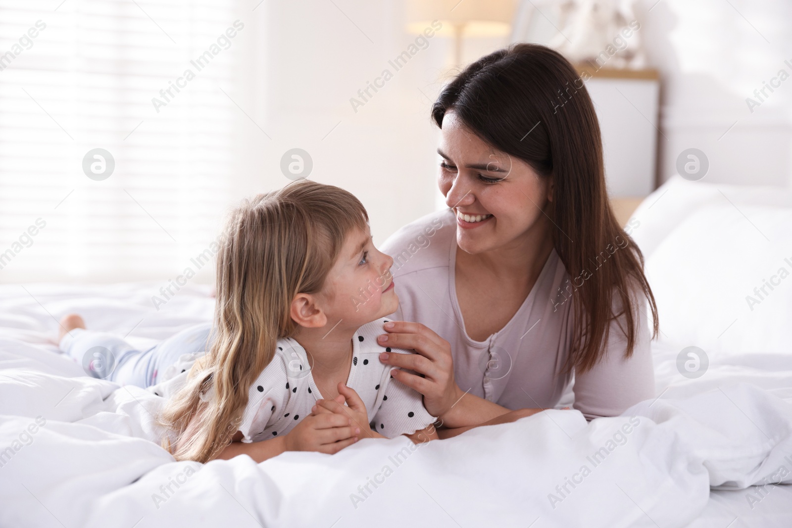 Mother and daughter on bed at home Photo of Mother and daughter on bed at home