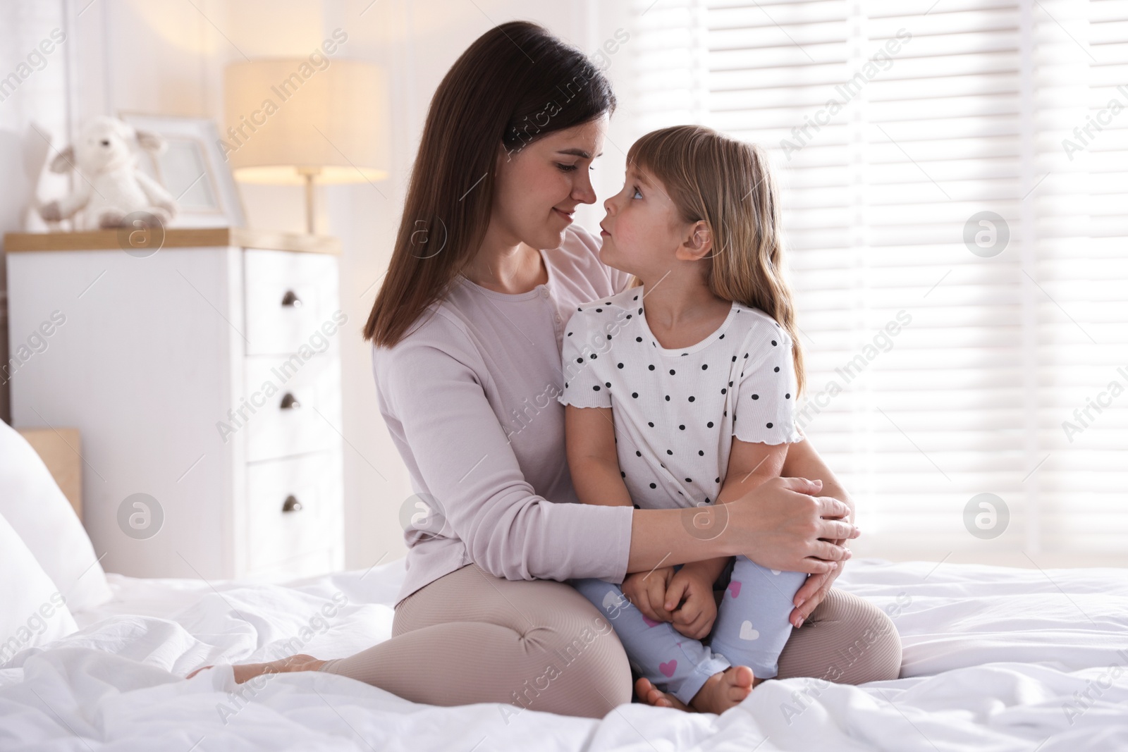 Mother and daughter on bed at home Photo of Mother and daughter on bed at home