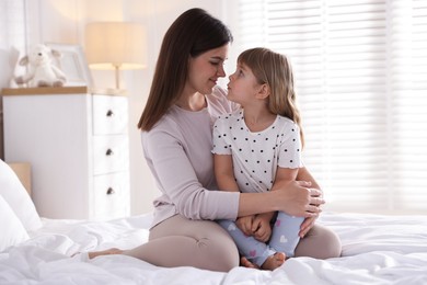 Photo of Mother and daughter on bed at home