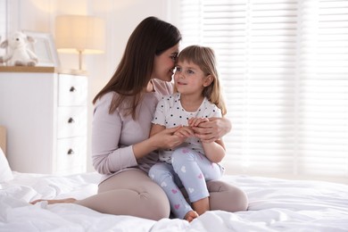 Photo of Mother and daughter on bed at home