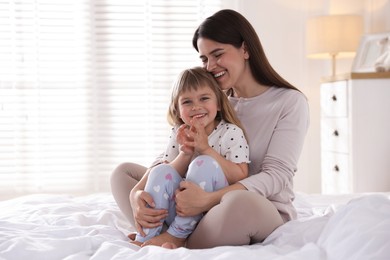 Photo of Mother and daughter on bed at home. Space for text
