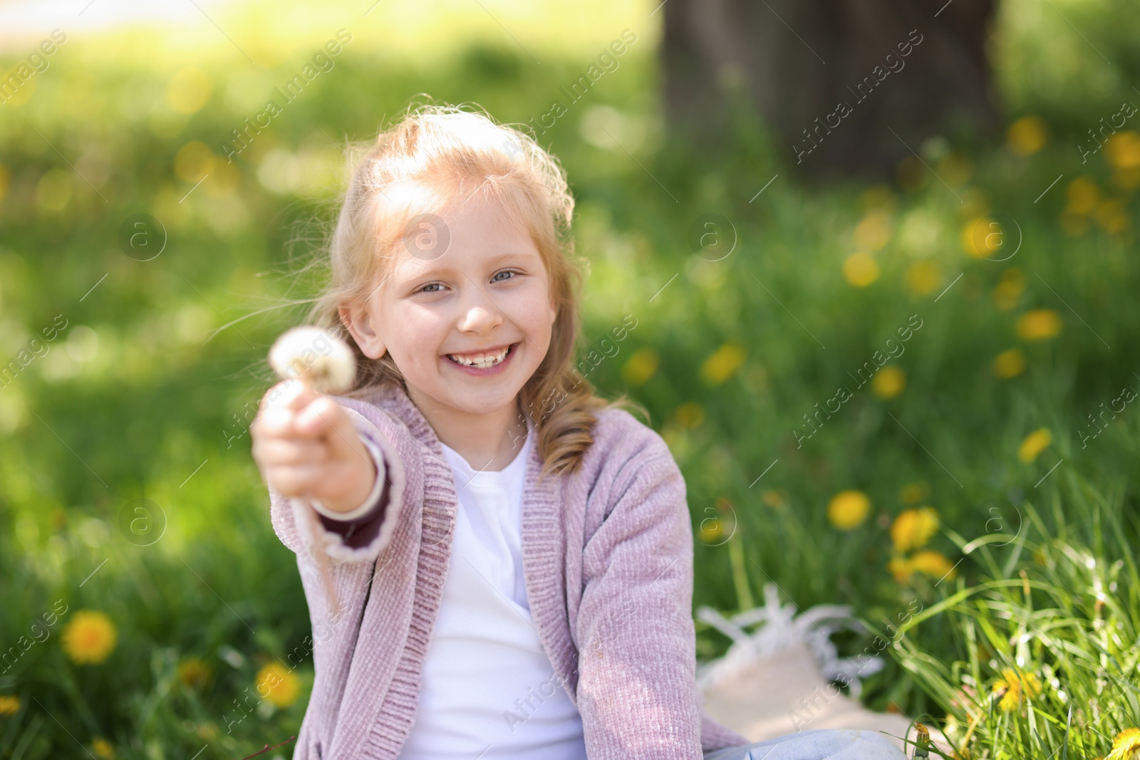 Cute little girl with beautiful dandelion outdoors, space for text Photo of Cute little girl with beautiful dandelion outdoors, space for text