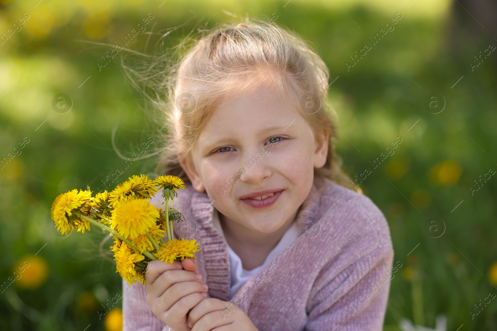 Cute little girl with beautiful dandelions outdoors Photo of Cute little girl with beautiful dandelions outdoors