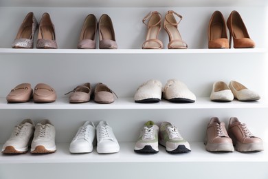 Photo of Different footwear on shelves indoors. Shoe storage