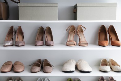 Photo of Different footwear on shelves indoors. Shoe storage
