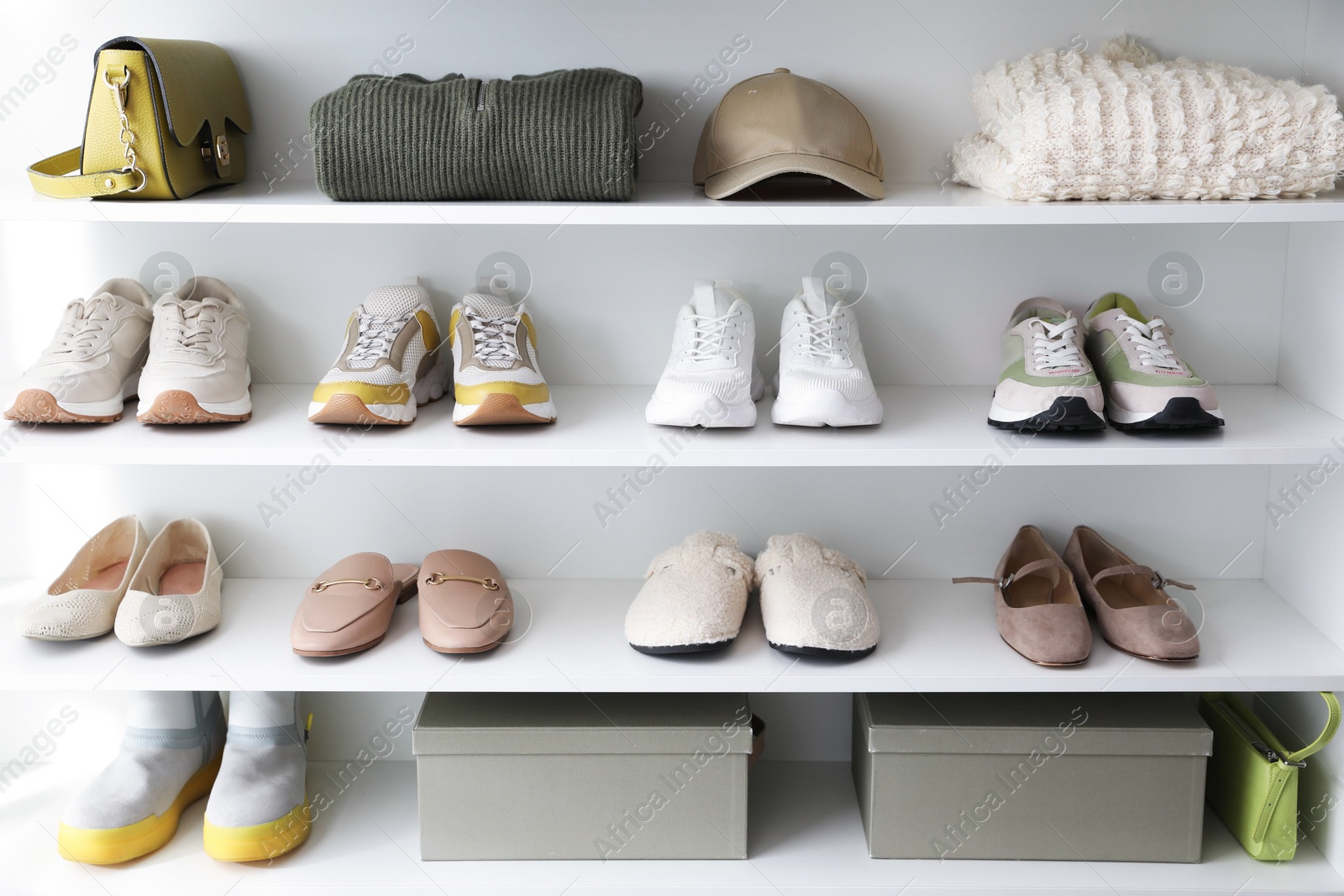 Different footwear, clothes and accessories on shelves indoors. Shoe storage Photo of Different footwear, clothes and accessories on shelves indoors. Shoe storage