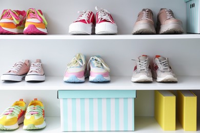 Photo of Different footwear on shelves indoors. Shoe storage