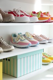 Photo of Different footwear on shelves indoors. Shoe storage