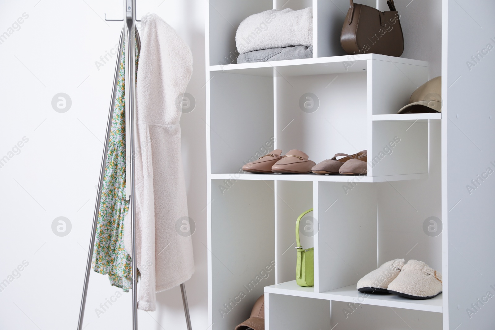 Shelving unit with different footwear, clothes and accessories indoors. Shoe storage Photo of Shelving unit with different footwear, clothes and accessories indoors. Shoe storage