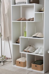 Photo of Shelving unit with different footwear and accessories indoors. Shoe storage