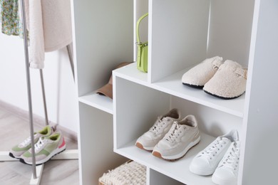 Photo of Shelving unit with different footwear and accessories indoors, closeup. Shoe storage