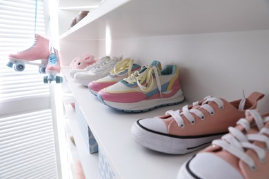 Photo of Different footwear on shelves indoors, closeup. Shoe storage