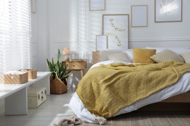 Photo of Comfortable bed with soft linens in stylish room. Home textile