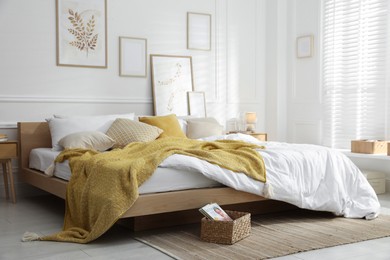 Photo of Comfortable bed with soft linens in stylish room. Home textile