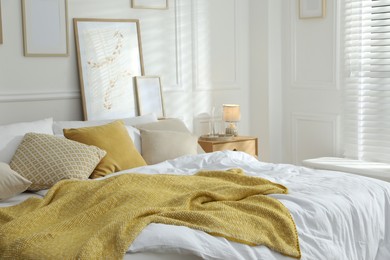 Photo of Comfortable bed with soft linens in stylish room. Home textile