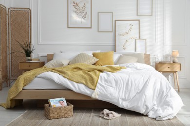 Photo of Comfortable bed with soft linens in stylish room. Home textile