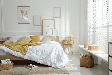 Photo of Comfortable bed with soft linens in stylish room. Home textile