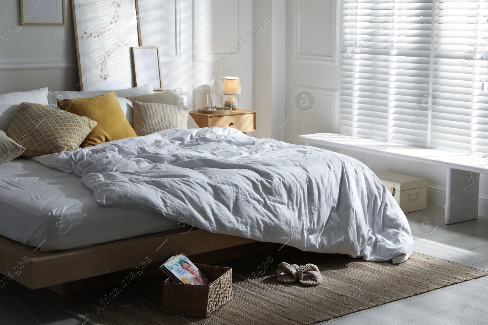Comfortable bed with soft linens in stylish room. Home textile Photo of Comfortable bed with soft linens in stylish room. Home textile
