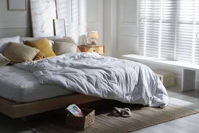 Photo of Comfortable bed with soft linens in stylish room. Home textile