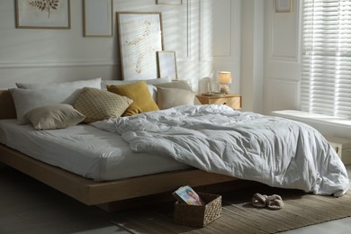 Photo of Comfortable bed with soft linens in stylish room. Home textile