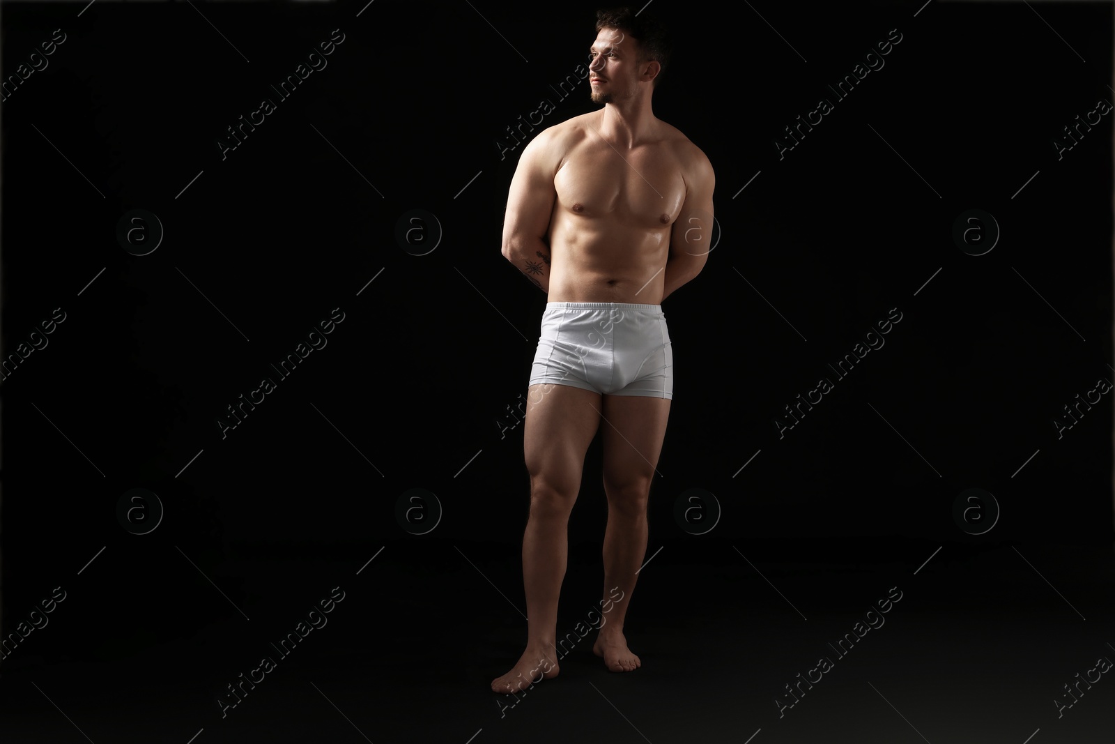 Young man in stylish white underwear on black background Photo of Young man in stylish white underwear on black background