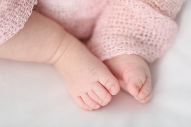 Photo of Little baby lying on bed indoors, closeup