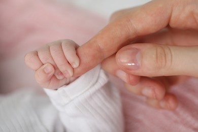 Photo of Mother with her little baby on bed indoors, closeup