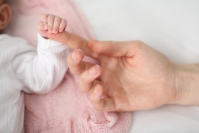 Photo of Mother with her little baby on bed indoors, top view