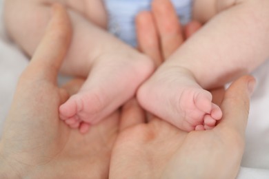 Photo of Mother with her little baby on bed indoors, closeup