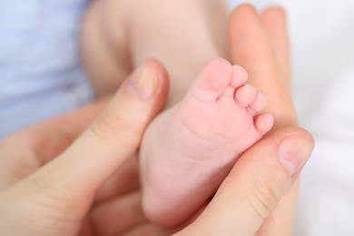Photo of Mother with her little baby on bed indoors, closeup