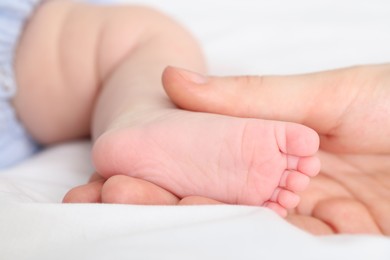 Photo of Mother with her little baby on bed indoors, closeup