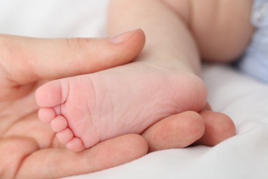 Photo of Mother with her little baby on bed indoors, closeup