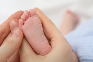 Photo of Mother with her little baby on bed indoors, closeup